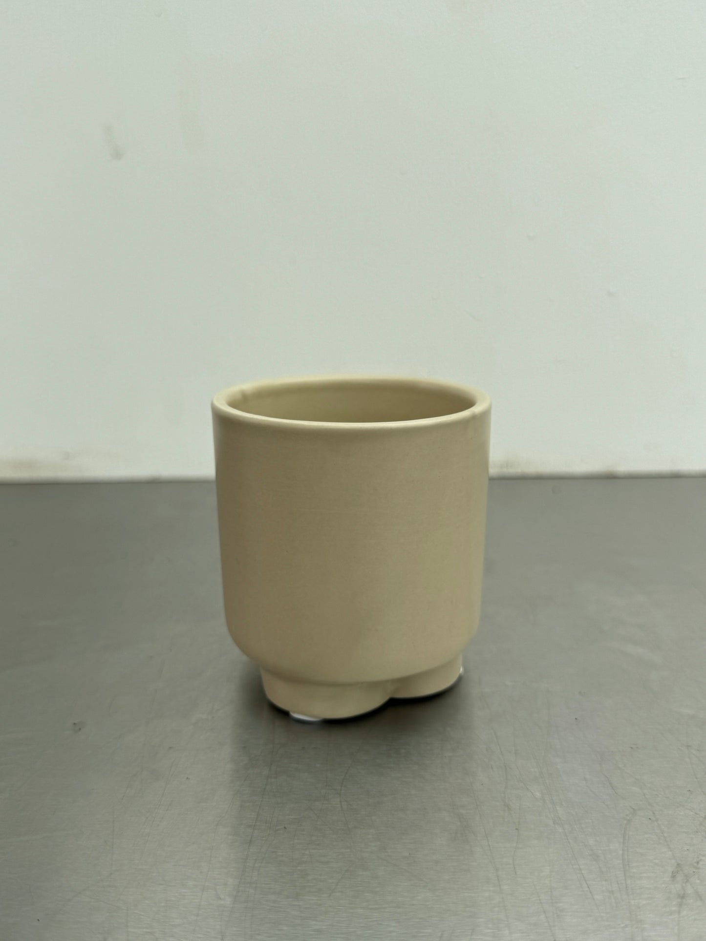 Beige 6 cm ceramic pot with a smooth matte texture, ideal for use as a cover pot or for planting tiny houseplants.